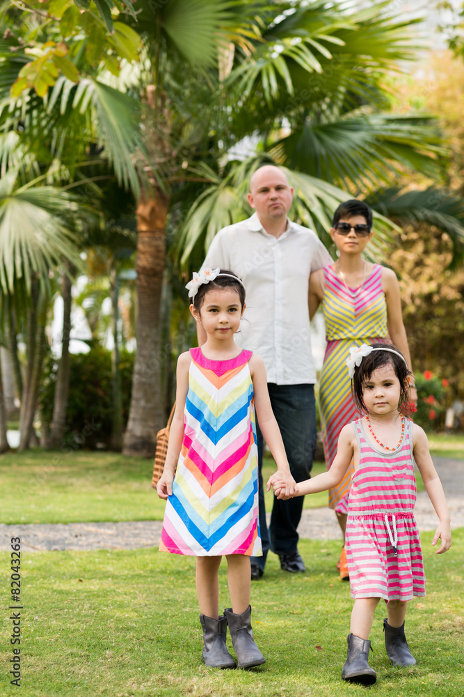 Obraz premium Mixed-race girls and parents in the park