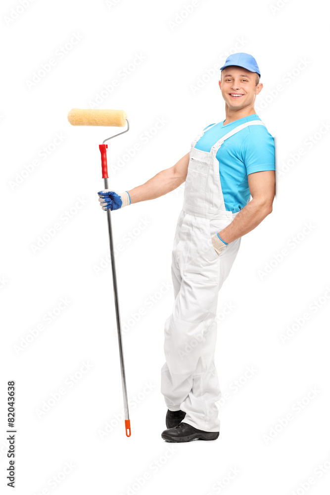 Relaxed young painter holding a paint roller Relaxed young painter holding a paint roller