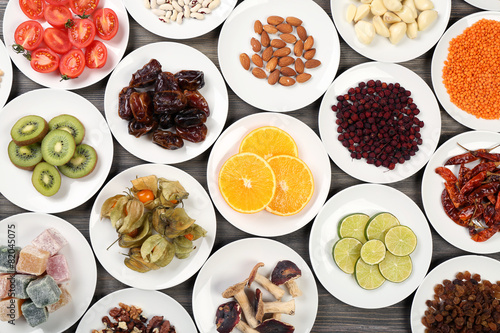 Different products on saucers on wooden table  top view