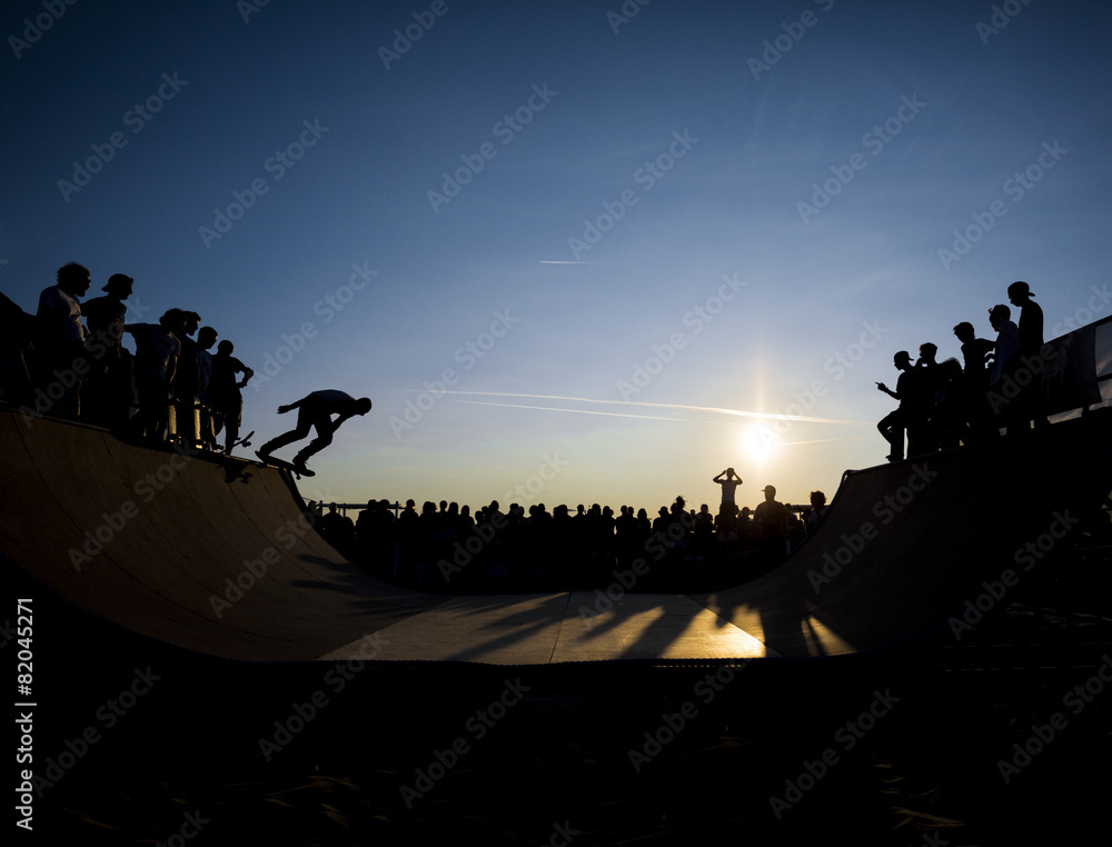Naklejka premium Skateboarder jumping on a ramp at dusk