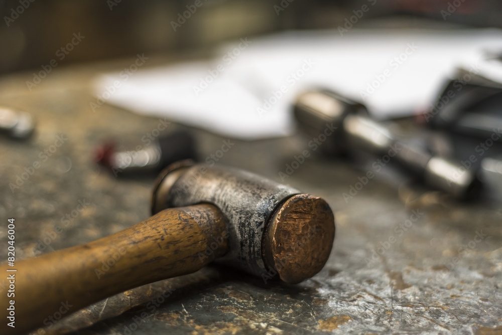 Messy workshop table with metal and wooden tools