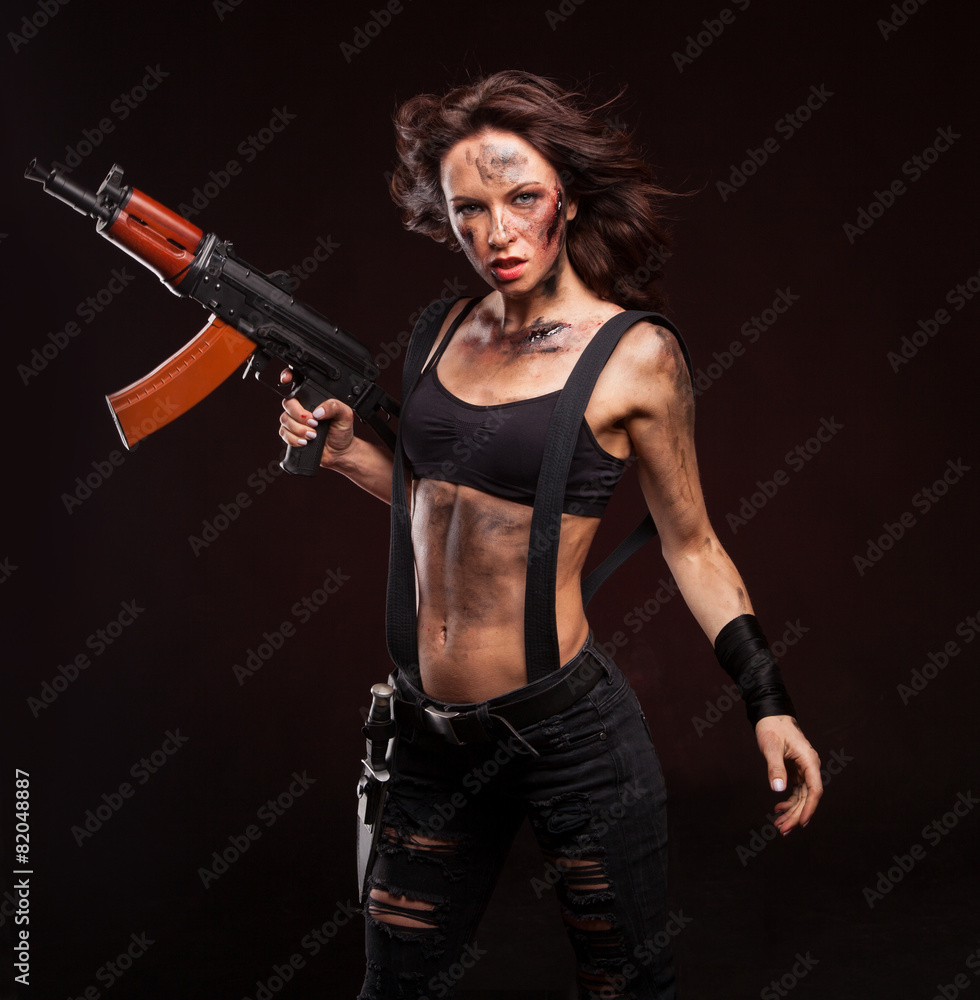 Beautiful young woman holding an automatic assault rifle. Beautiful young woman holding an automatic assault rifle.