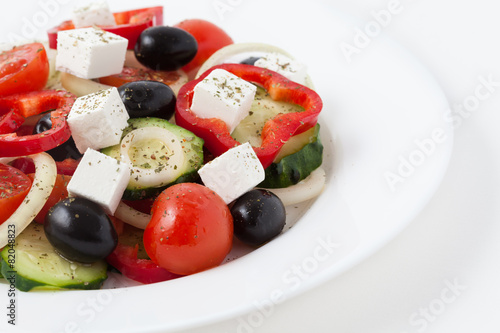 Greek salad with olives, tomato, cucumber and feta in a white di