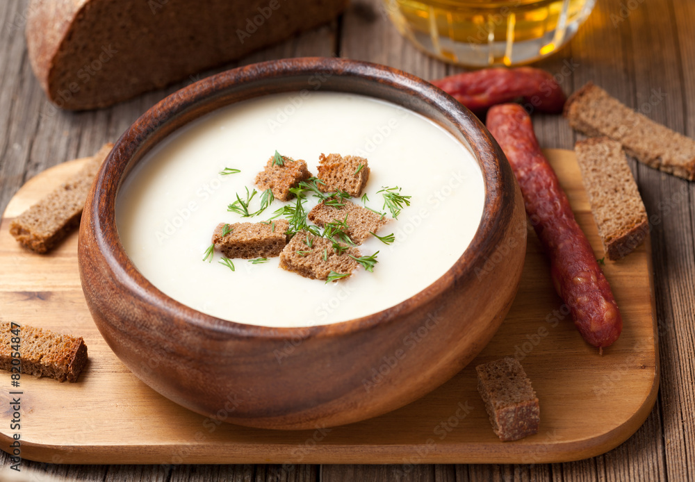 Fototapeta premium Traditional beer cream soup with dill croutons and sausage in wo