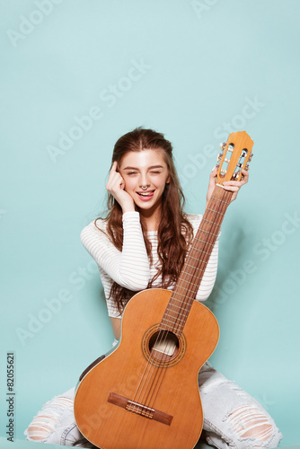smiling beautiful young girl posing with guitar