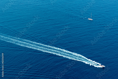 Boat surf foam aerial from prop wash in blue sea
