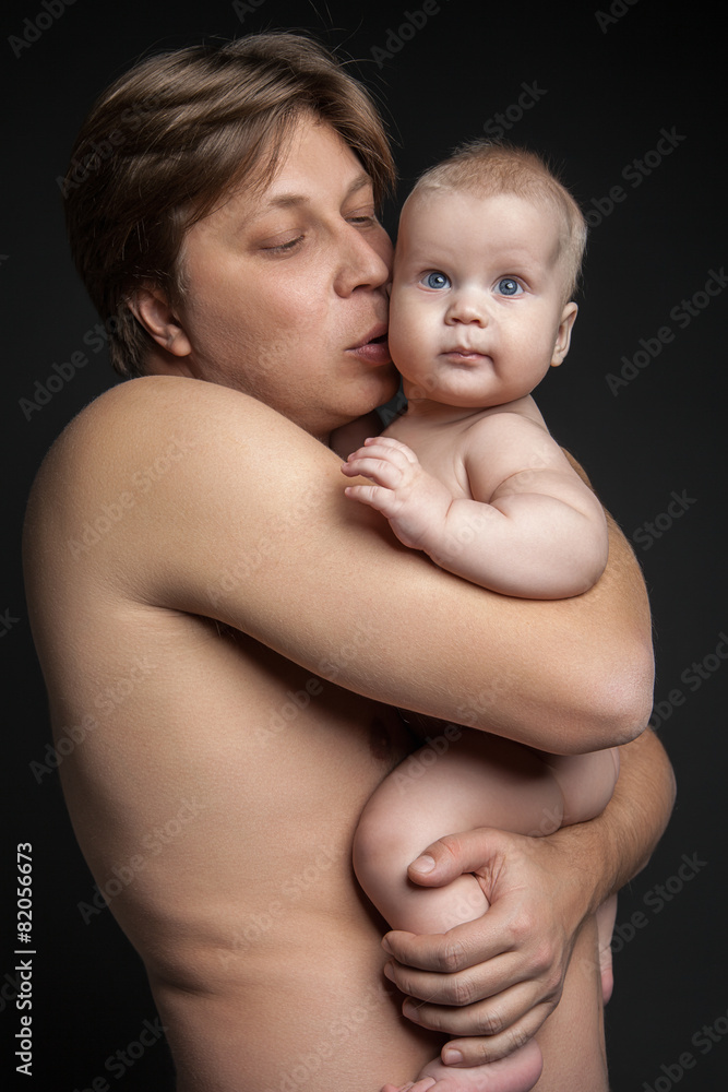 Happy father hugging and kissing his newborn baby Happy father hugging and kissing his newborn baby