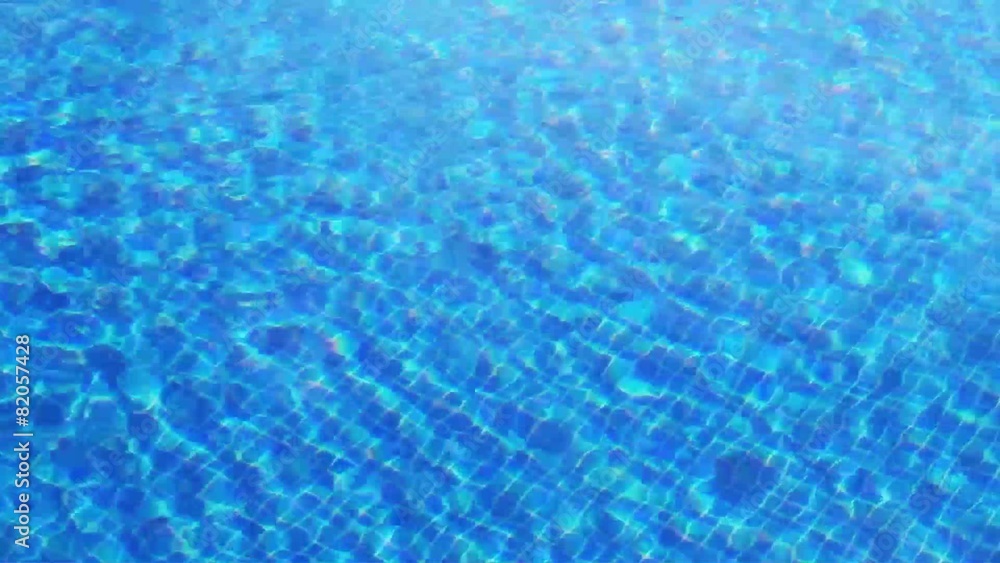Waving clear water in swimming pool with blue bottom Waving clear water in swimming pool with blue bottom