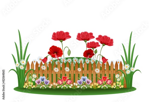 Beautiful bed with different flowers and a wooden fence