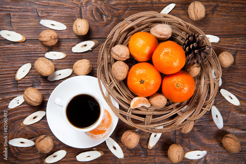 Cup of coffee with tangerines and walnut