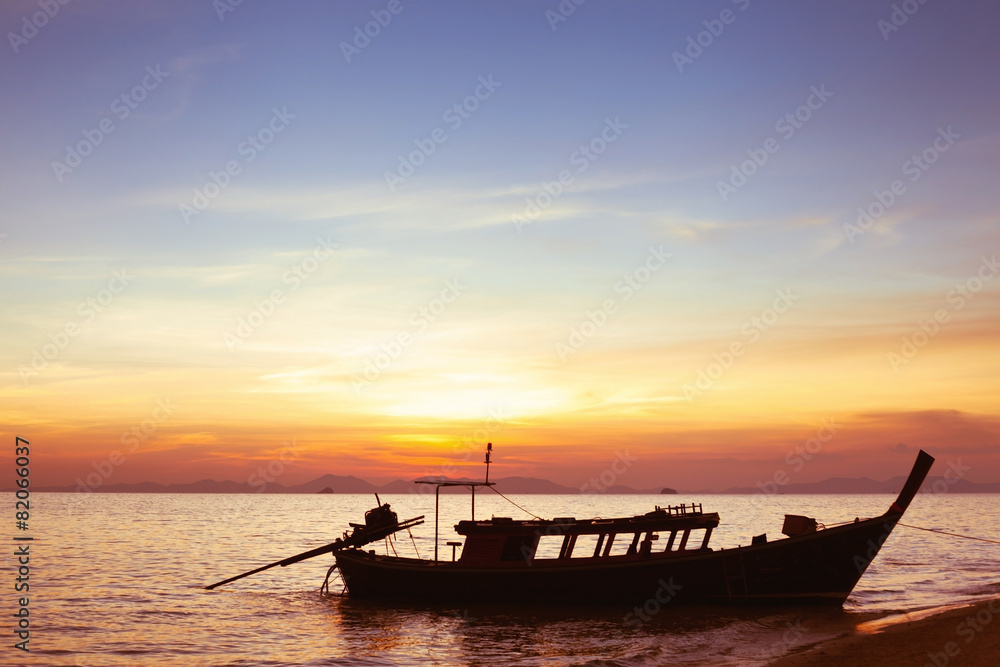 beautiful sunset on the beach with silhouette of boat