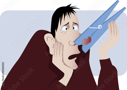 Nasal congestion. Man with a clothespin on his nose