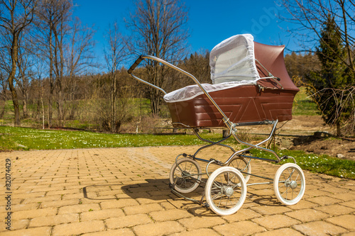 Retro style baby carriage outdoors on sunny day