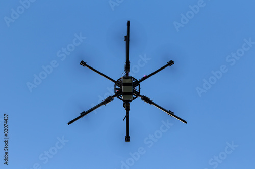 Professional drone hexacopter flying on blue sky