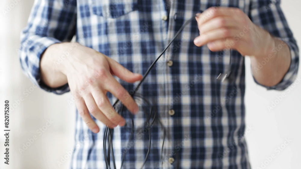 close up of man untangling wires close up of man untangling wires
