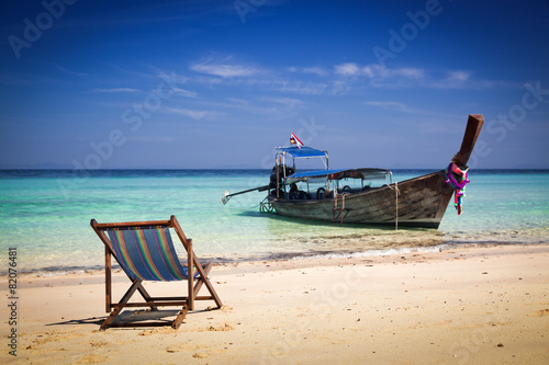 Exotic beach holiday background with beach chair and long tail b
