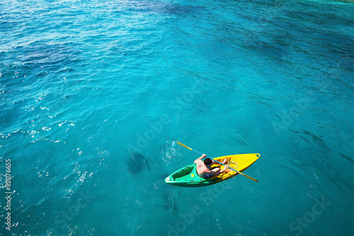 top view of man paddling on kayak in turquoise water