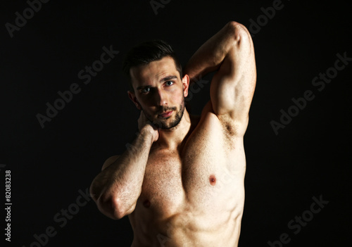 Muscle young man on black background