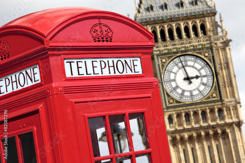 London red telephone box booth with westminster british houses of parliament building and Big Ben clock tower in the background photo