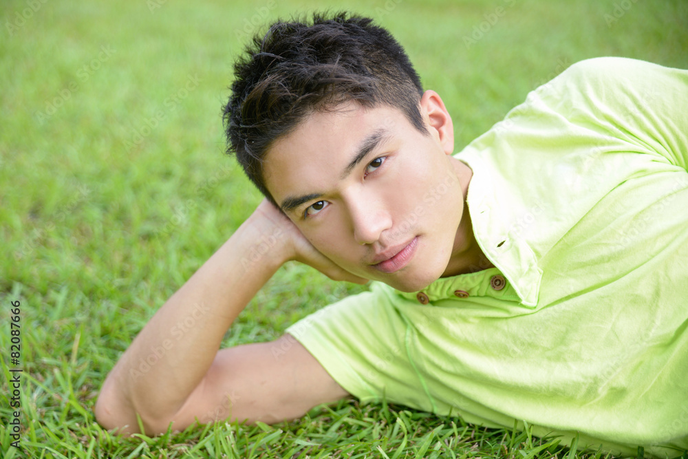 Portrait of Asian student lying on the green grass Portrait of Asian student lying on the green grass