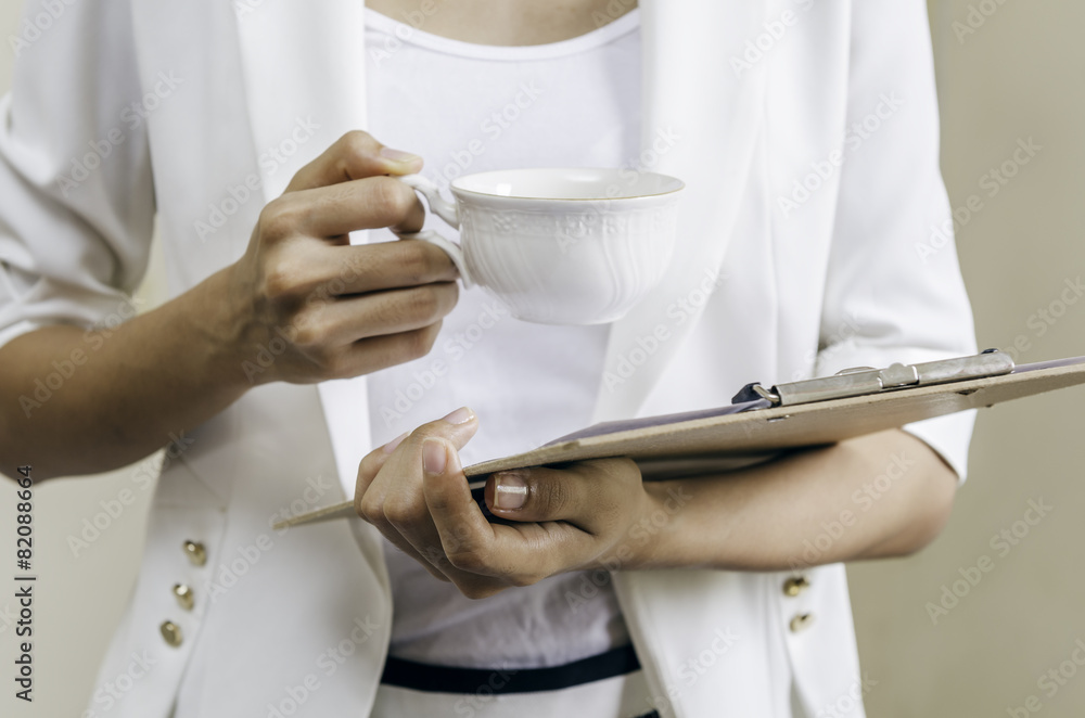 businesswoman reviewing report with a cup of tea