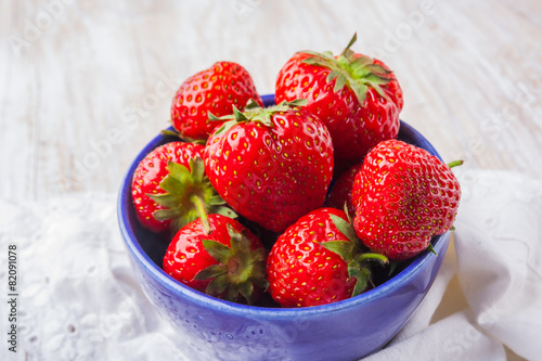 Fresh strawberries in a small blue bowl