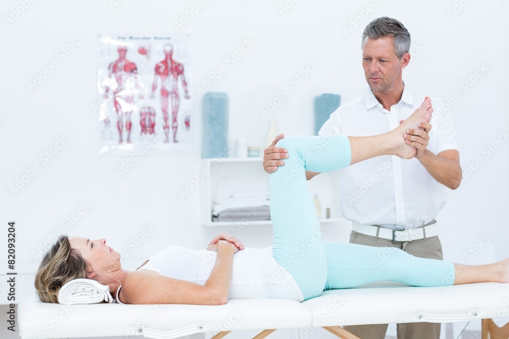 Fototapeta premium Doctor stretching his patients leg