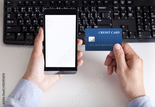 man makes the payment by credit card on holding phone