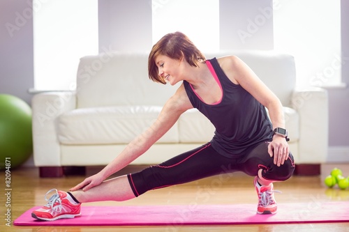 Fit woman stretching on exercise mat