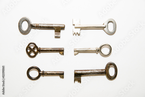 Six old keys to the safe on a white background