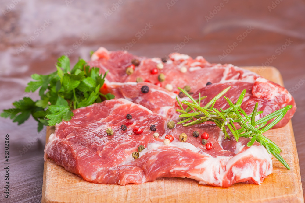 Raw pork chops on a wooden cutting board Raw pork chops on a wooden cutting board