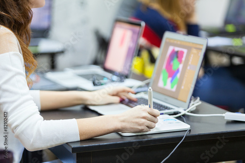 Caucasian woman drawing with pen on graphic tablet