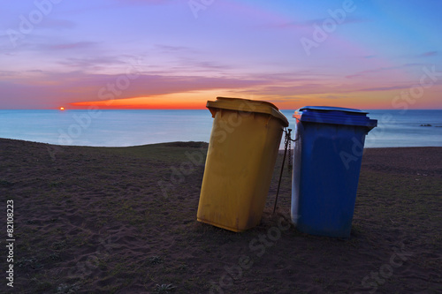 paper bins on beach at sunset