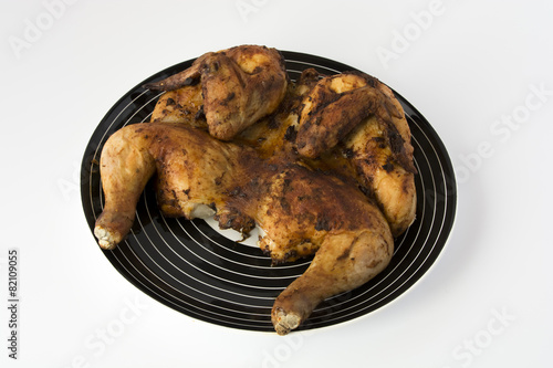 Roasted chicken on a striped black dish