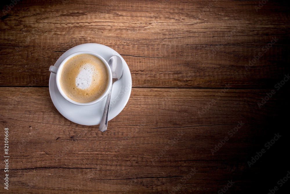 Cup of freshly brewed aromatic cappuccino standing on a wooden t Cup of freshly brewed aromatic cappuccino standing on a wooden t
