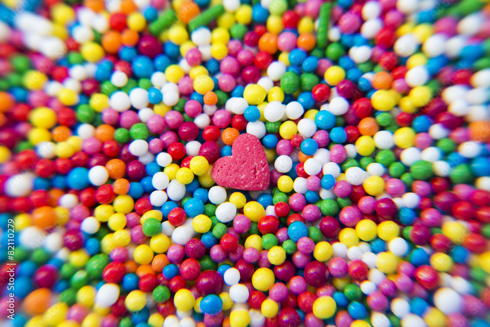 Macro of Sugar Heart over colorfull balls powder background Macro of Sugar Heart over colorfull balls powder background