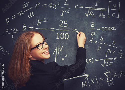 happy girl student, the teacher writes on  blackboard chalk form