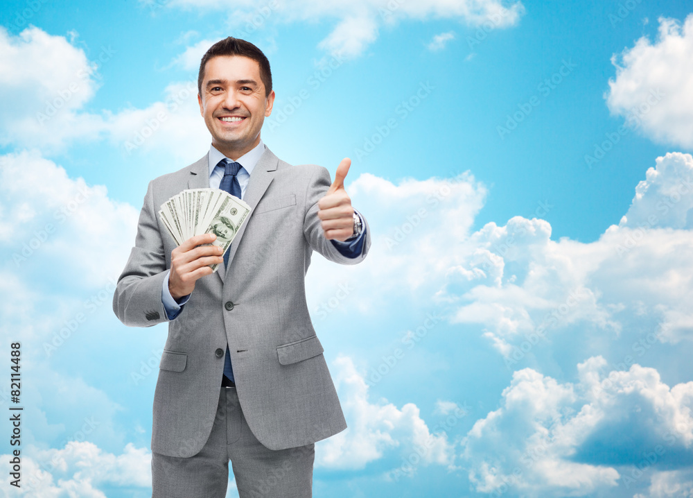 smiling businessman with money showing thumbs up smiling businessman with money showing thumbs up