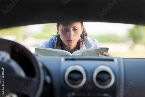 Caucasian businesswoman has a car problem and reads a car instru