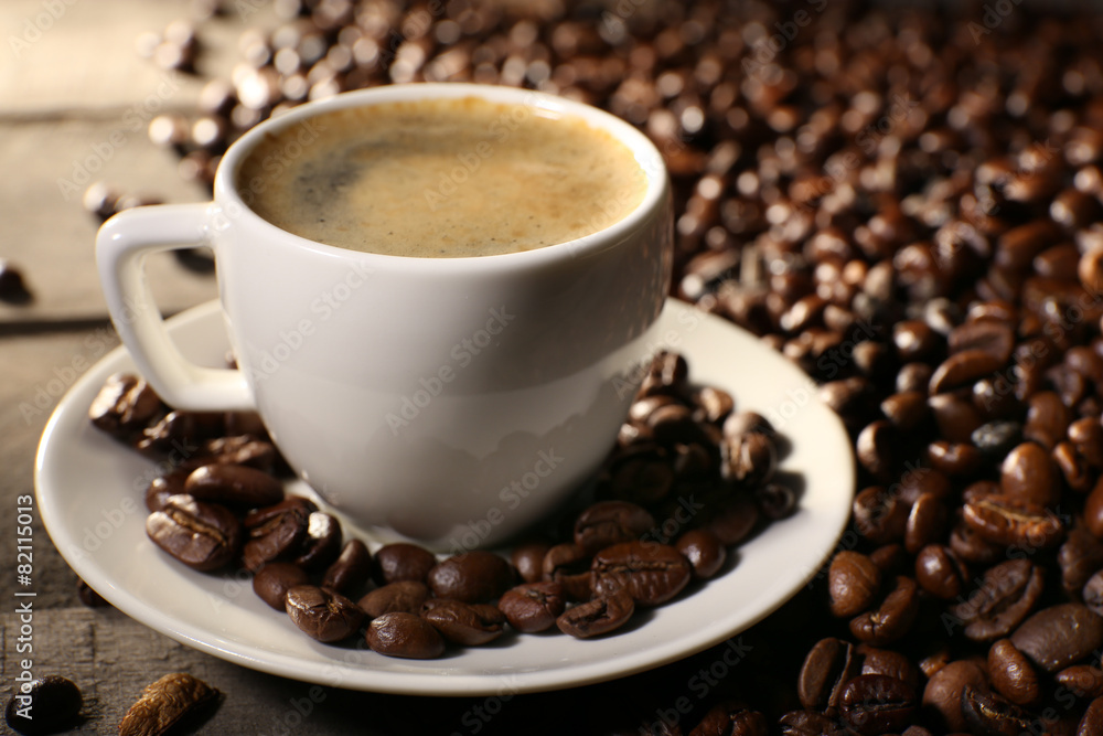 Cup of coffee with grains, closeup