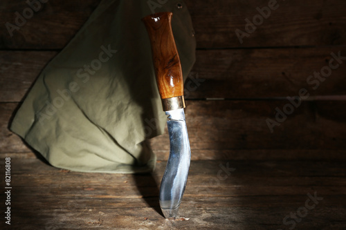 Hunting knife on wooden background