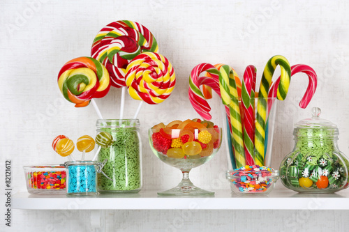 Colorful candies in jars on shelves close-up