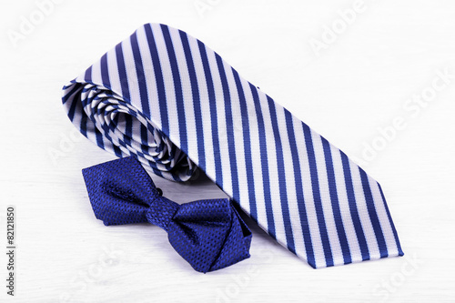 Male necktie and bow tie on wooden table background