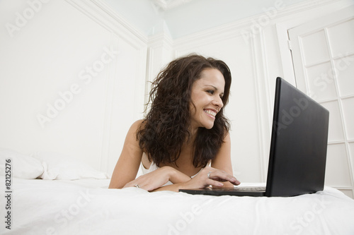 Hispanic woman looking at laptop photo