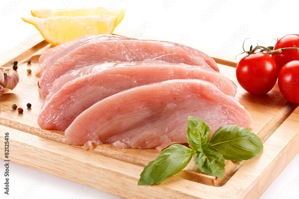 Raw chicken breasts on cutting board on white background Raw chicken breasts on cutting board on white background