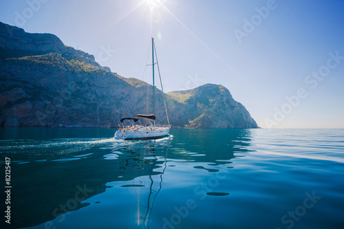 Yacht sailing along the shore the sea in calm weather.