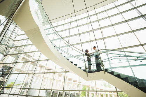Business people talking on office staircase