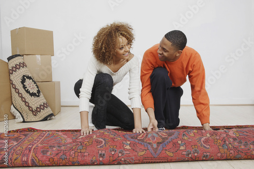 African couple rolling rug