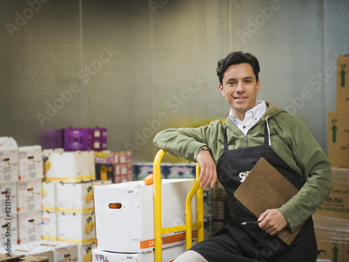 Hispanic worker carting boxes in walk-in freezer