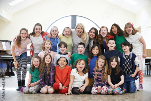 Large Group Of Children With Teacher Enjoying Drama Workshop Tog